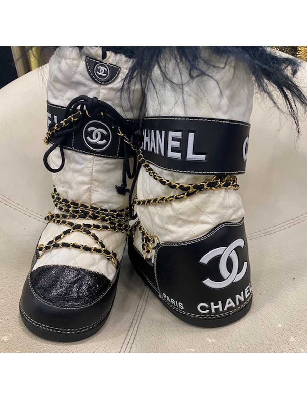 Bottes après-ski Chanel noires et blanches chaînes dorées