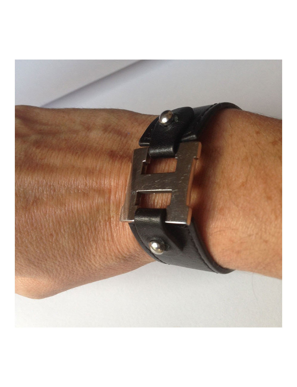 Bracelet HERMES cuir noir et "H" palladié