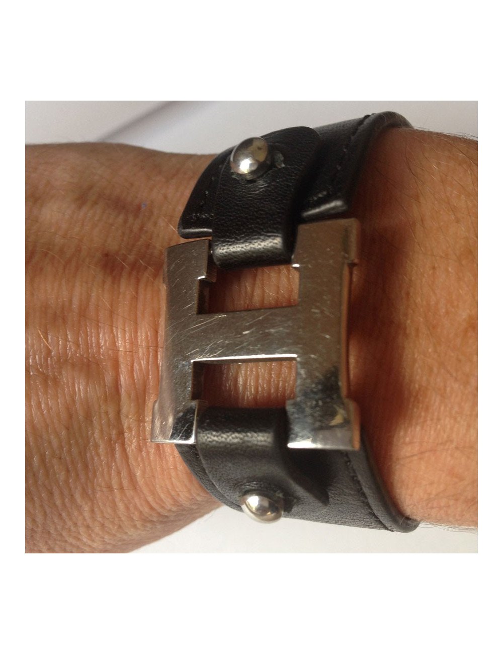 Bracelet HERMES cuir noir et "H" palladié