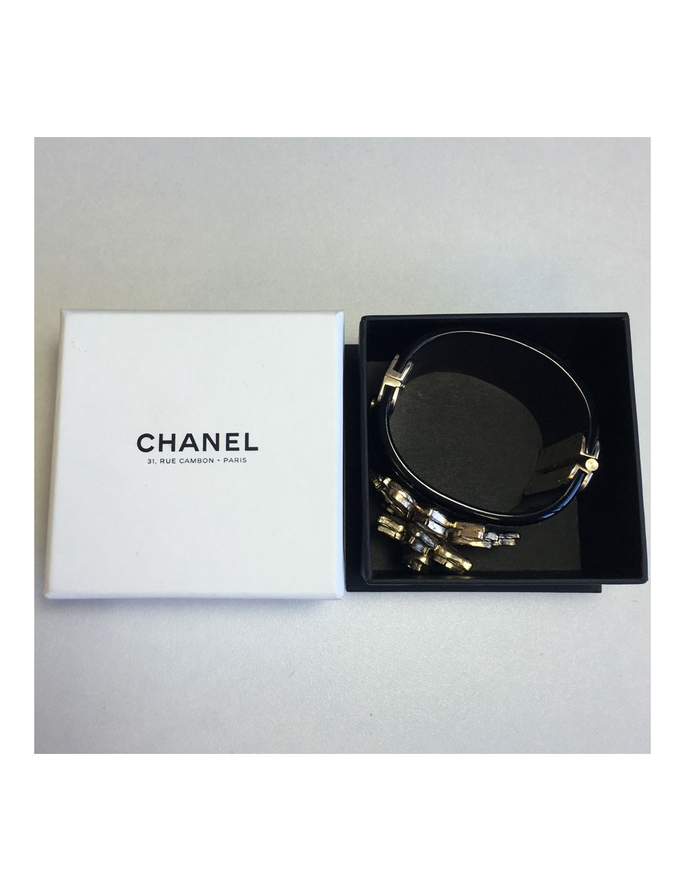 Manchette CHANEL en résine noire et fleur en métal doré et résine transparente