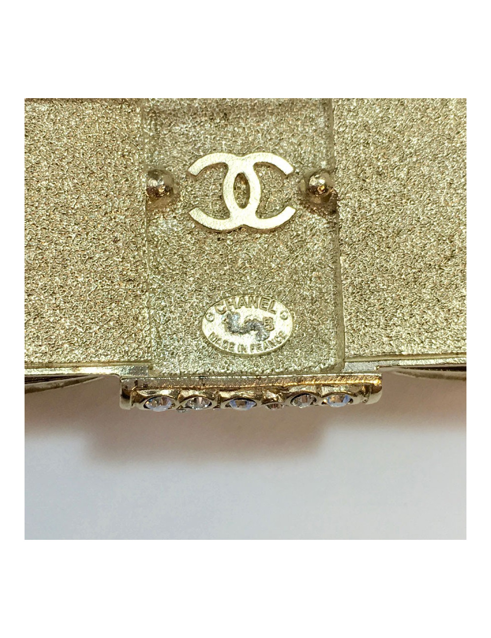 CHANEL knot brooch in rhinestones and pale gold metal