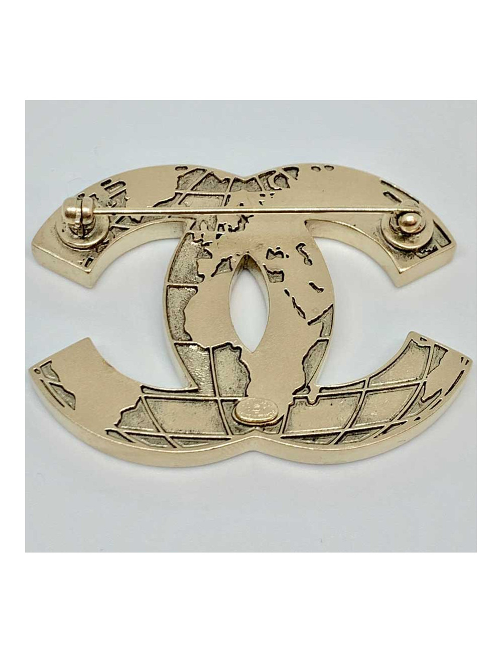 Broche mappemonde CC CHANEL en métal doré